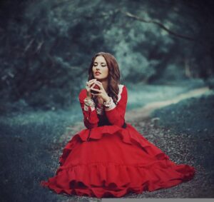 Pombagira de vestido vermelho, abaixada em uma estrada na floresta.
